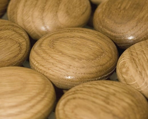 Close-up of hand-turned oak cabinet knobs showing the ring-patterned grain