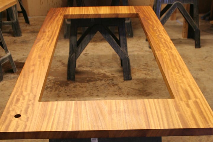 Iroko worktop with large rectangular cutout resting on workshop trestles