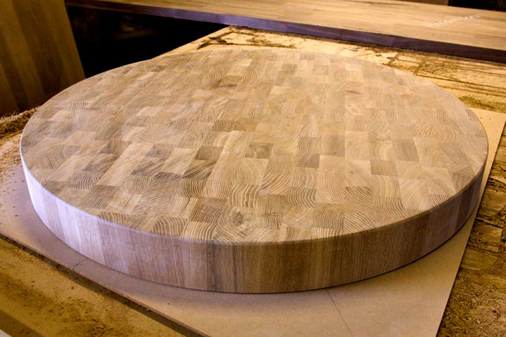 Large round end grain oak table top freshly sanded in the workshop