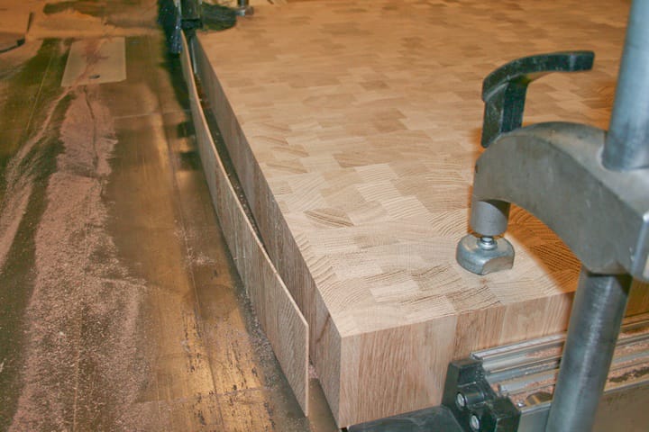 End grain oak worktop clamped on the workbench with a thin offcut sliced away