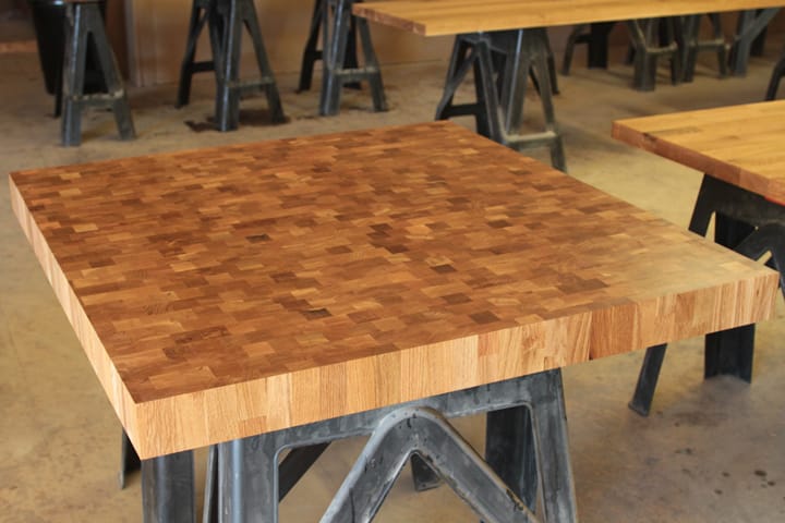 Square end grain oak table top on a cast iron trestle base
