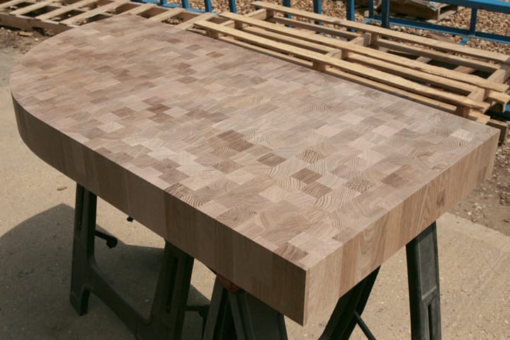 Curved-end end grain oak worktop resting on trestles outdoors