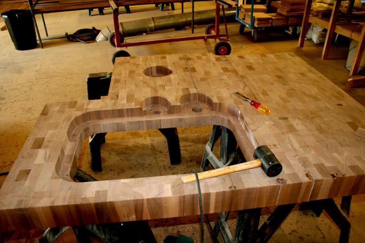 End grain walnut worktop with sink and tap cut-outs being made in the workshop