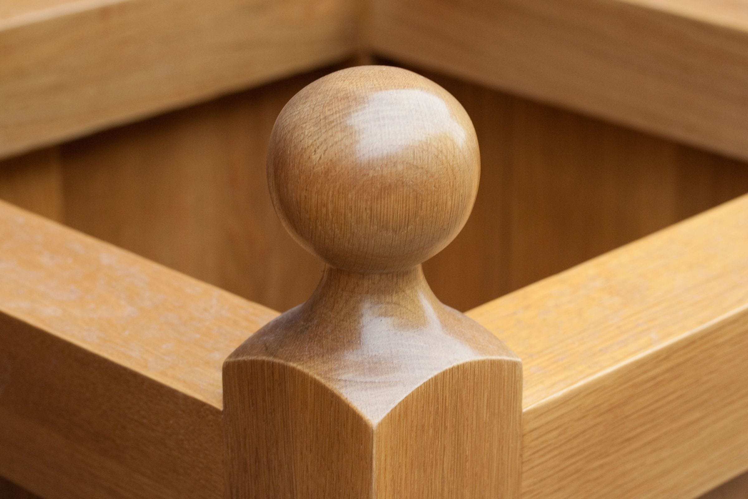 Close-up of a turned ball finial on the corner post of an oak planter