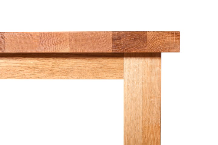 Corner detail of an oak dining table showing thick stave-built top and square leg