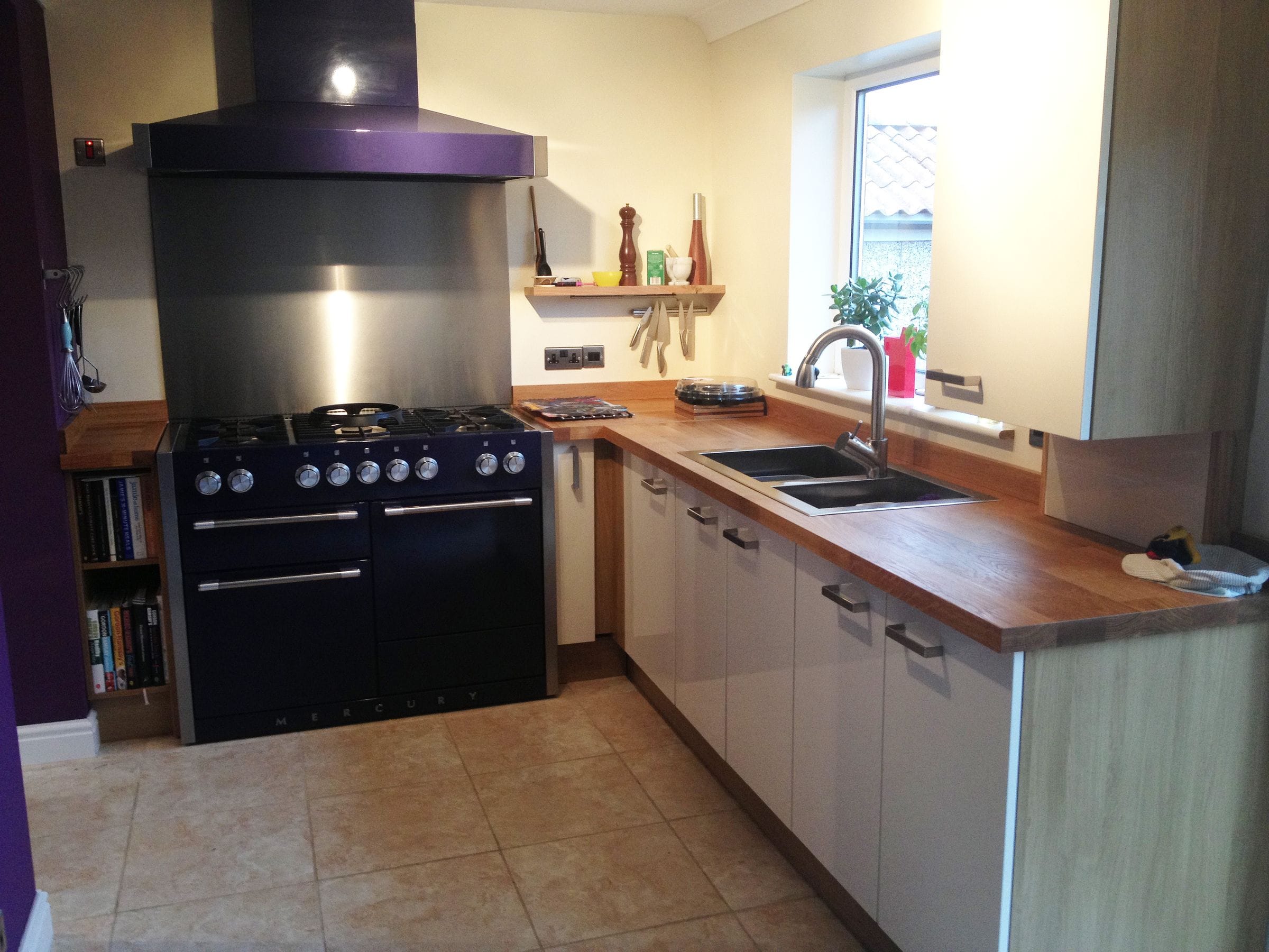 Kitchen corner with black range cooker and oak worktops around a stainless sink