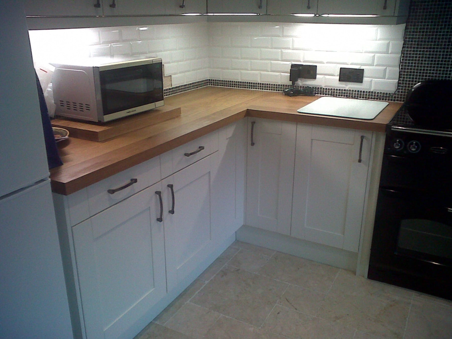 Oak worktops on white Shaker units with white metro tile splashback