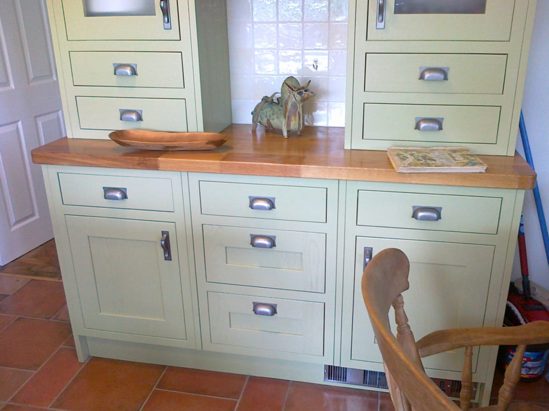 Green painted dresser with oak worktop displaying a carved wooden bowl
