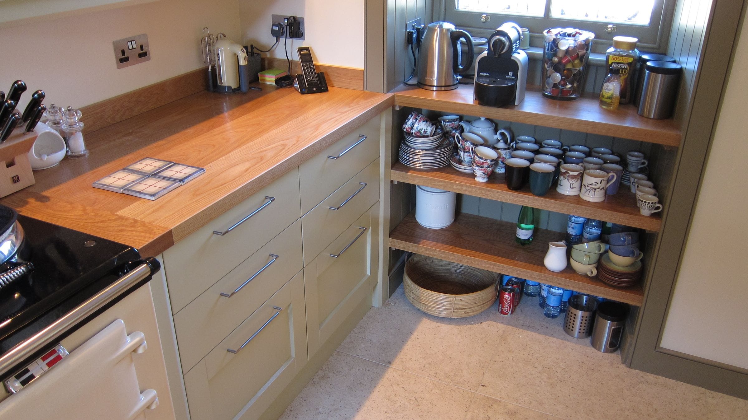 Oak worktop and matching open shelves stacked with mugs and crockery