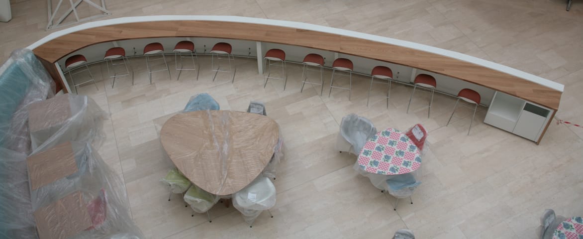 Aerial view of a sweeping curved wooden breakfast bar with stools in a cafe