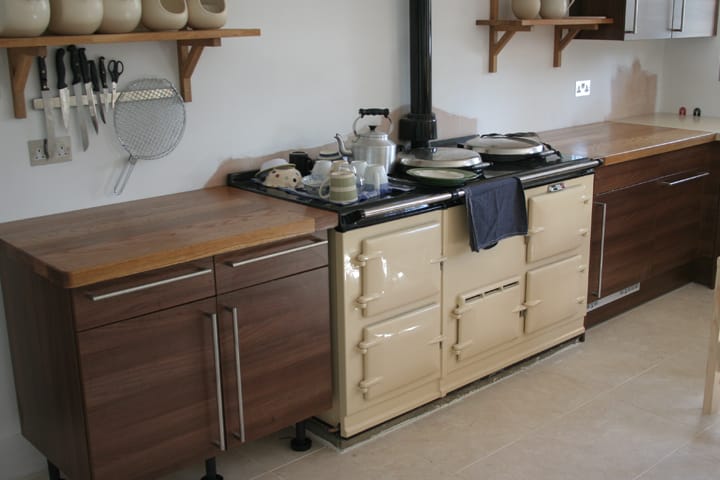 Oak worktops on dark walnut cabinets flanking a cream Aga range cooker
