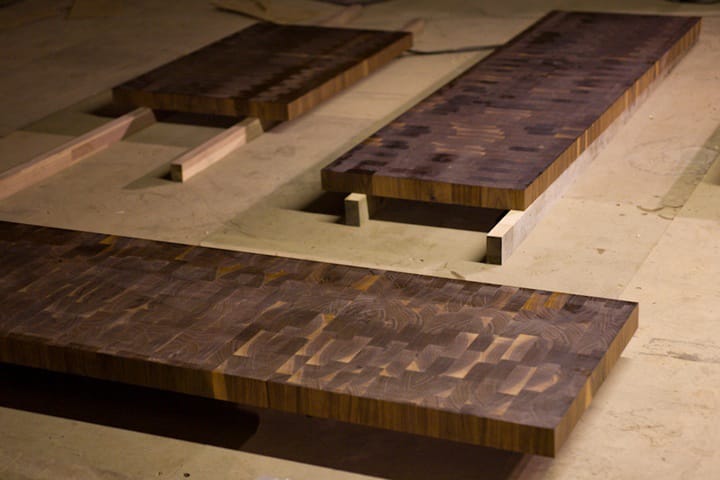Dark walnut end grain worktop sections laid out in the workshop