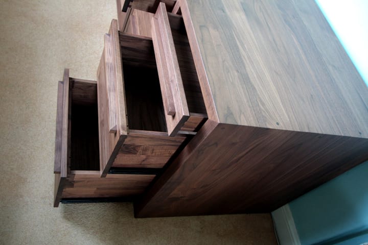 Overhead view of a walnut cabinet with three drawers pulled open