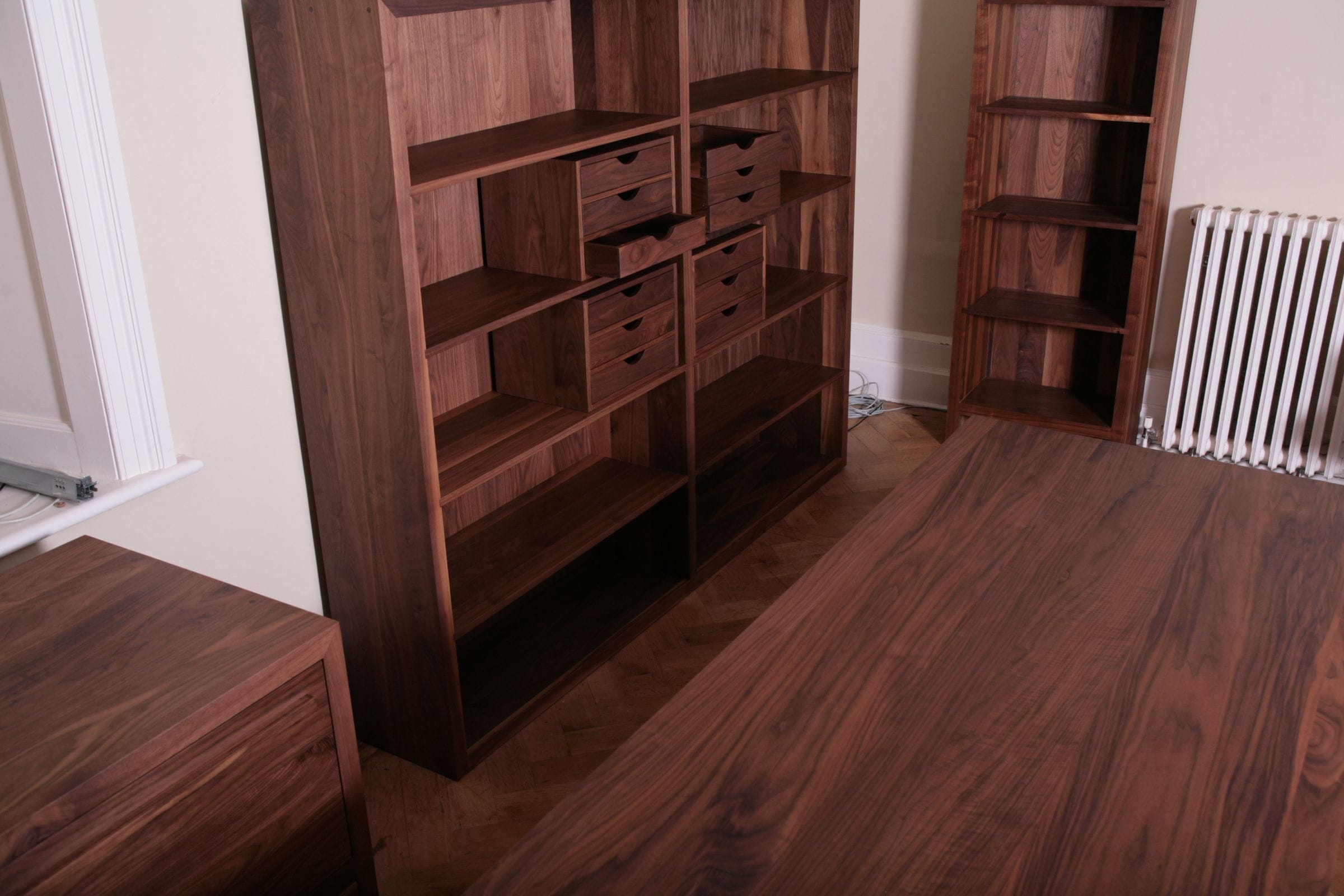 Walnut study furniture including shelving units with small drawers and a matching desk