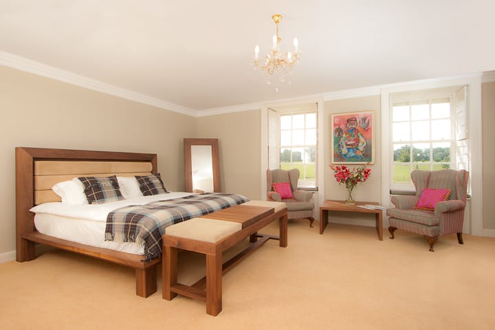 Bedroom with walnut bed frame, upholstered bench and full-length mirror