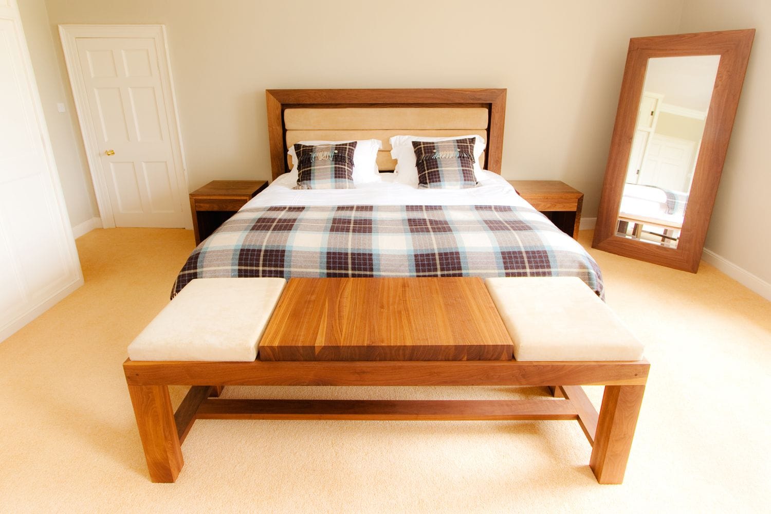 Walnut bed with tartan throw, bedside tables, bench and framed mirror