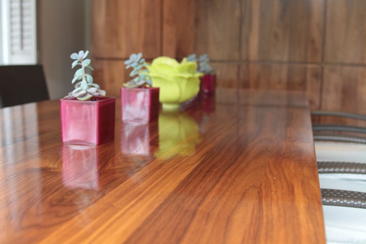 Polished walnut tabletop with succulents in pink glass pots and a lime-green bowl