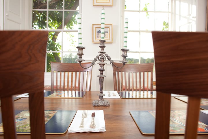 Silver candelabra with striped candles centred on a walnut dining table
