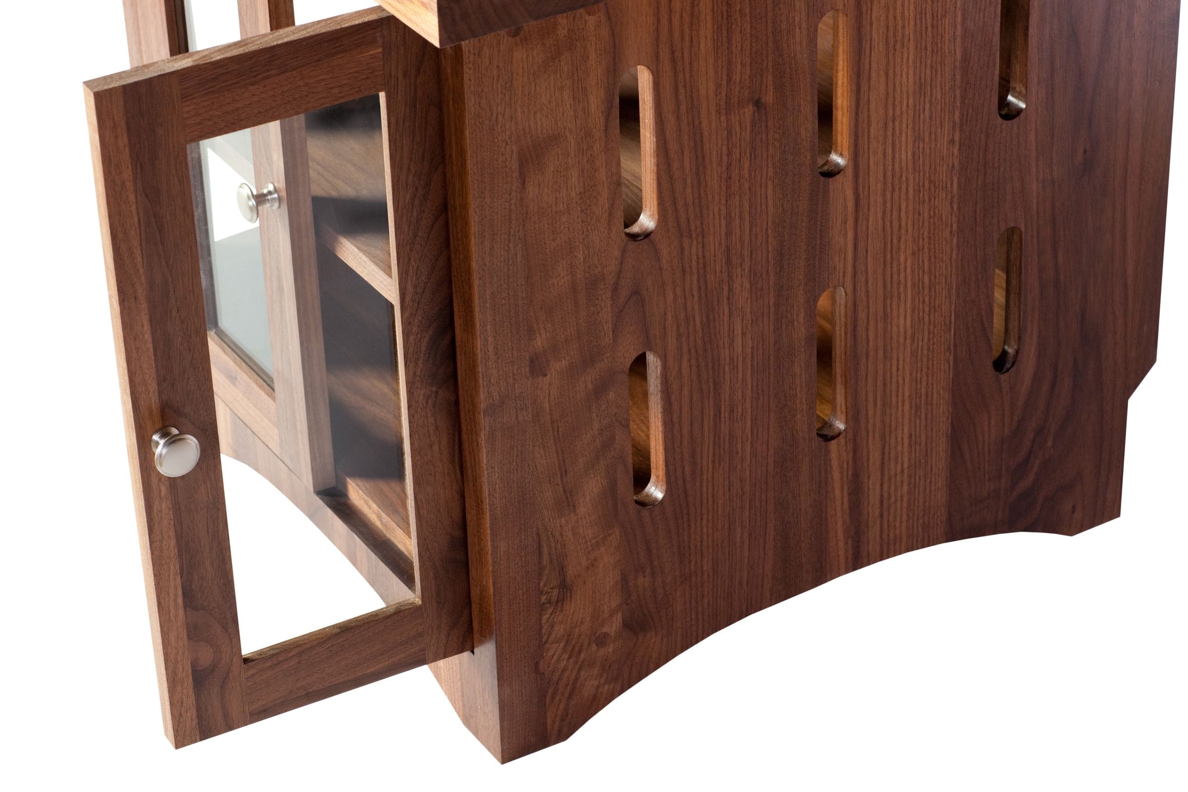 Side view of a walnut cabinet with slotted panel and open glazed door