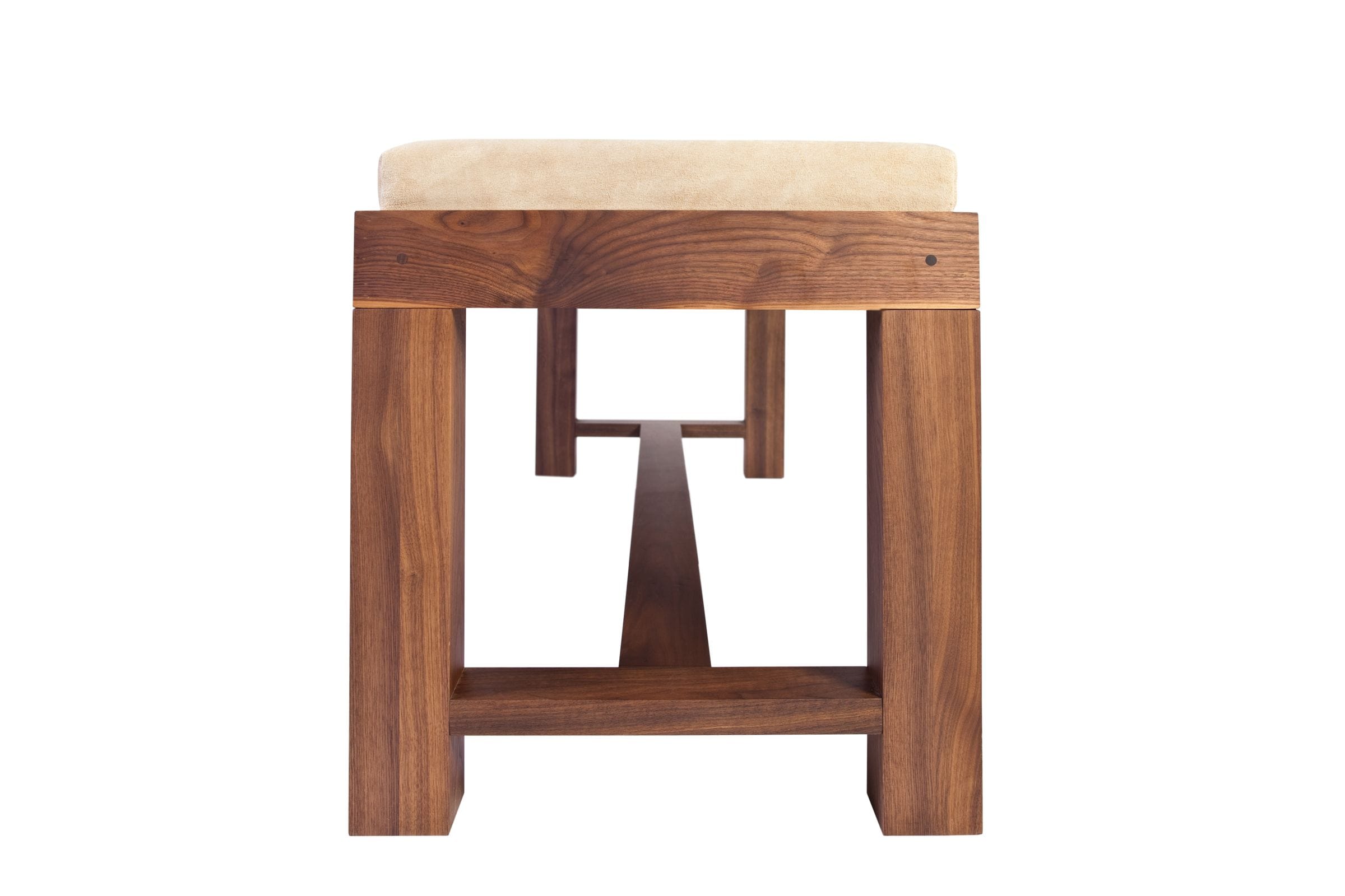 End view of a walnut bench showing cushioned seat and cross-stretcher frame
