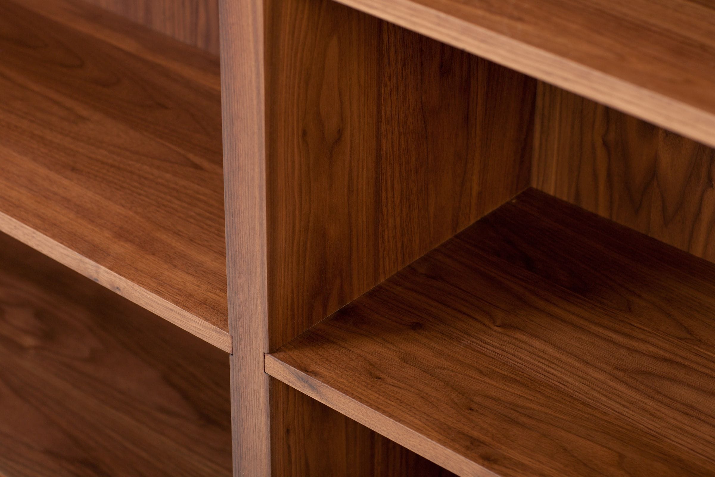 Close-up of walnut bookcase shelving showing grain and precise shelf joints