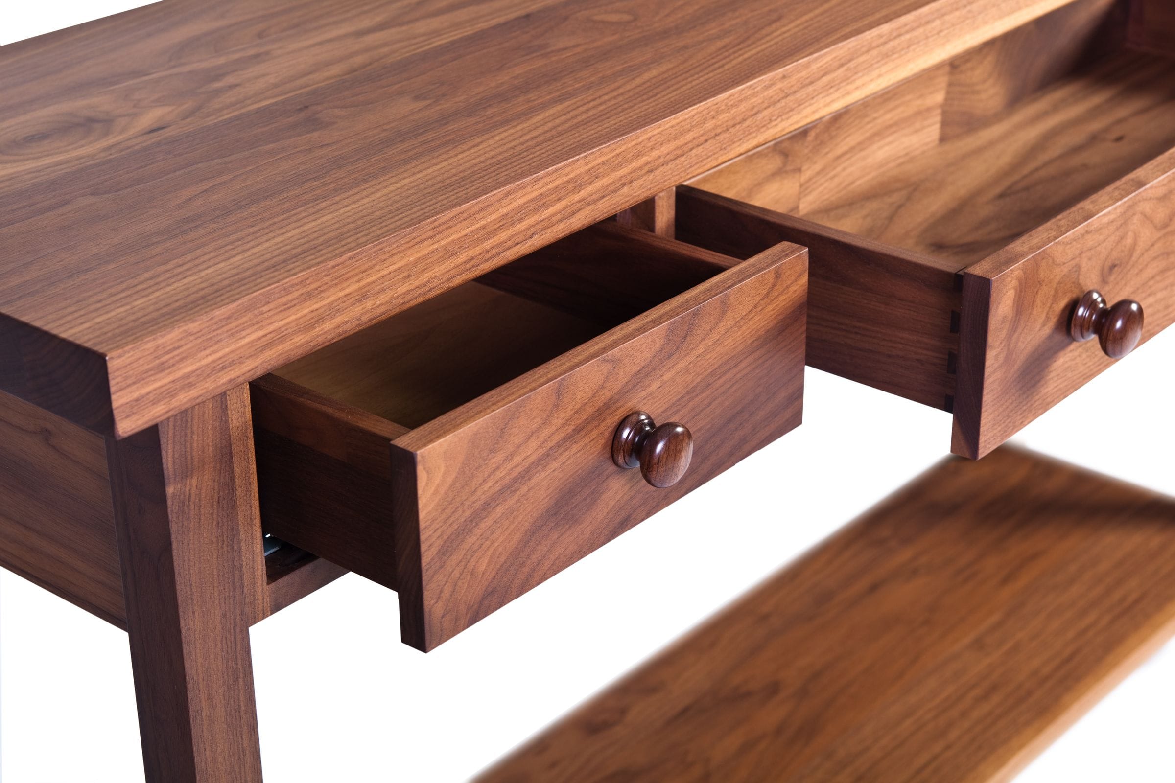 Close-up of open dovetailed walnut drawers with turned wooden knobs