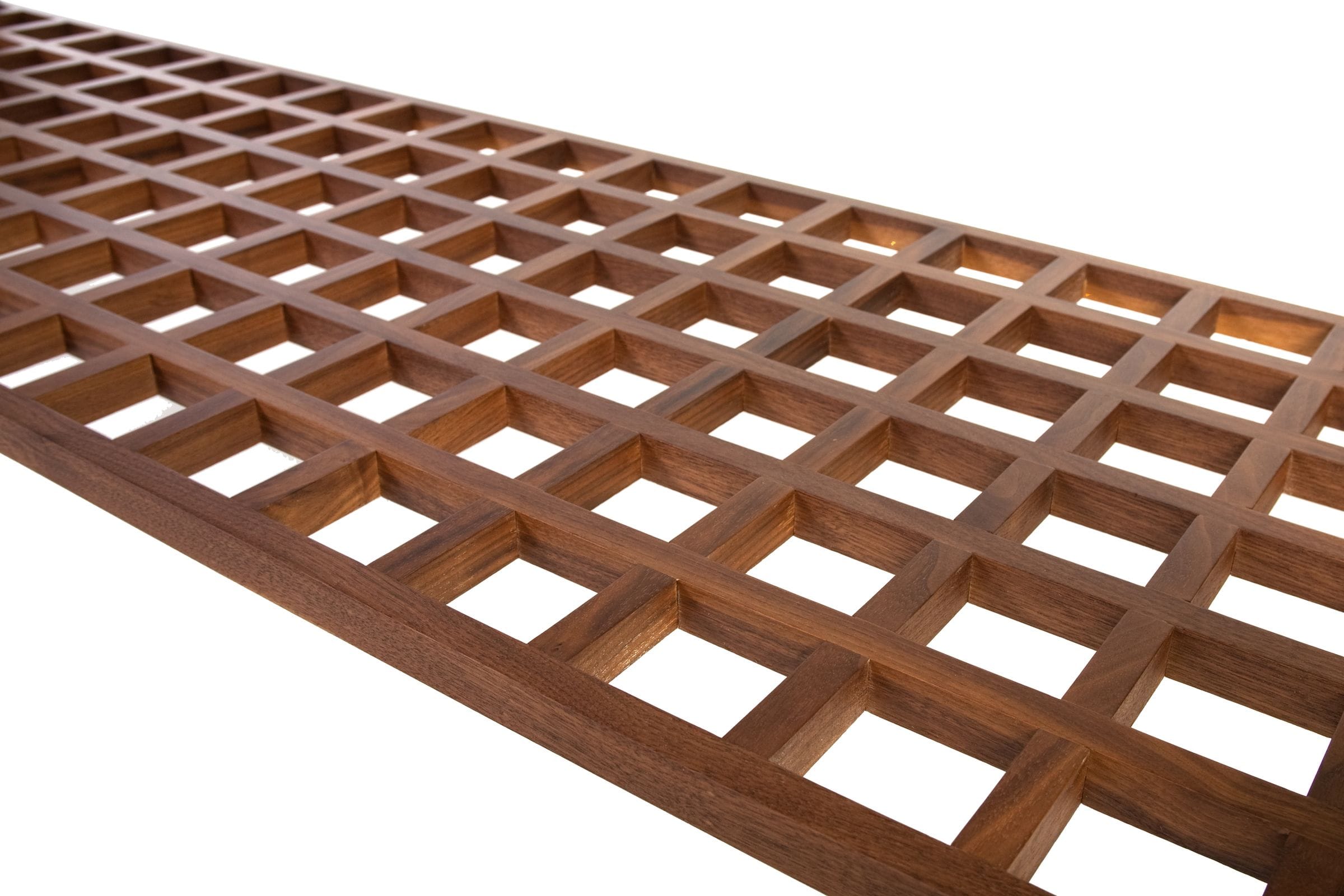 Close-up of a handmade walnut lattice shelf with square open grid pattern