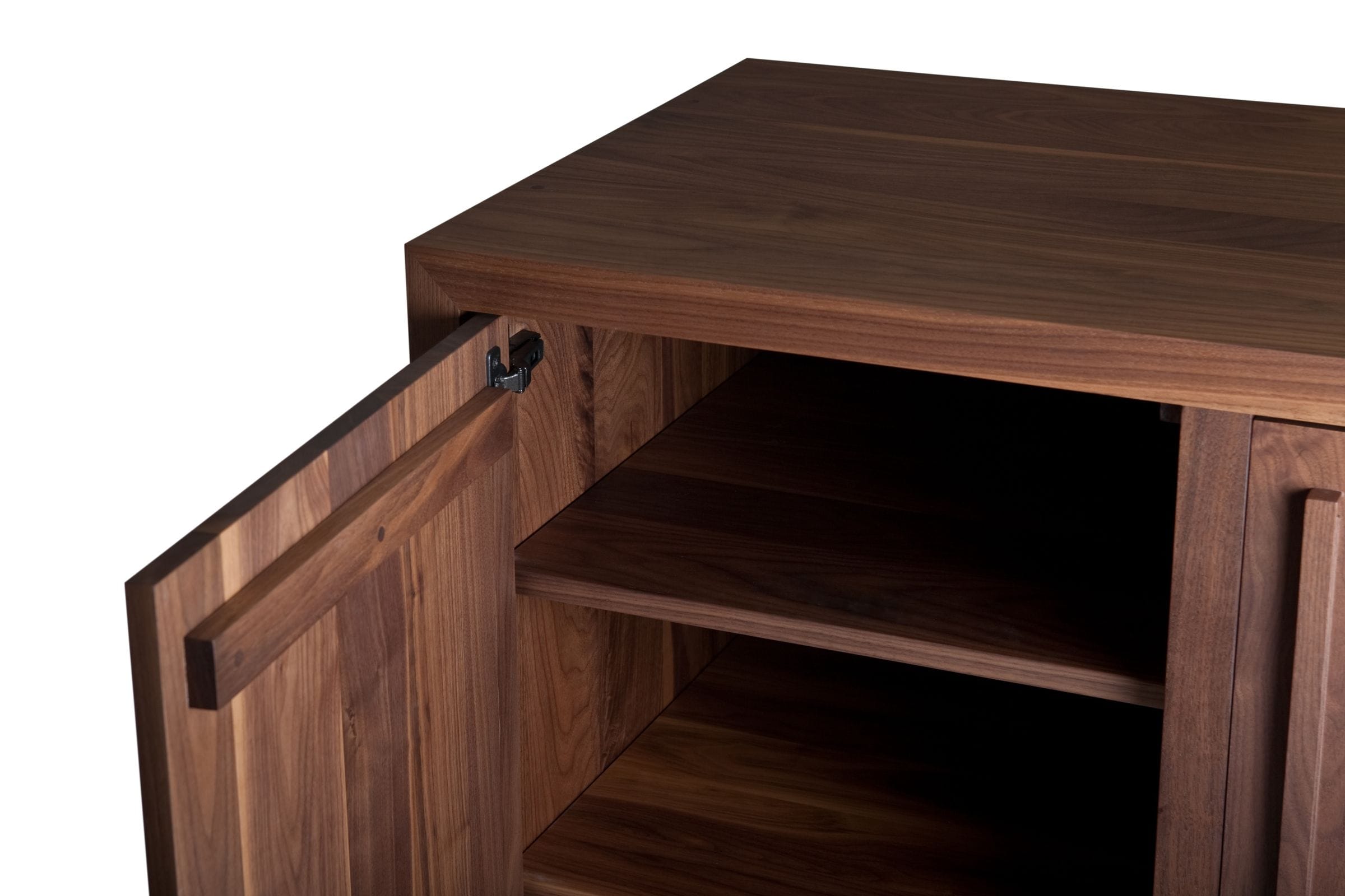 Close-up of an open walnut cabinet door, hinge and interior shelving