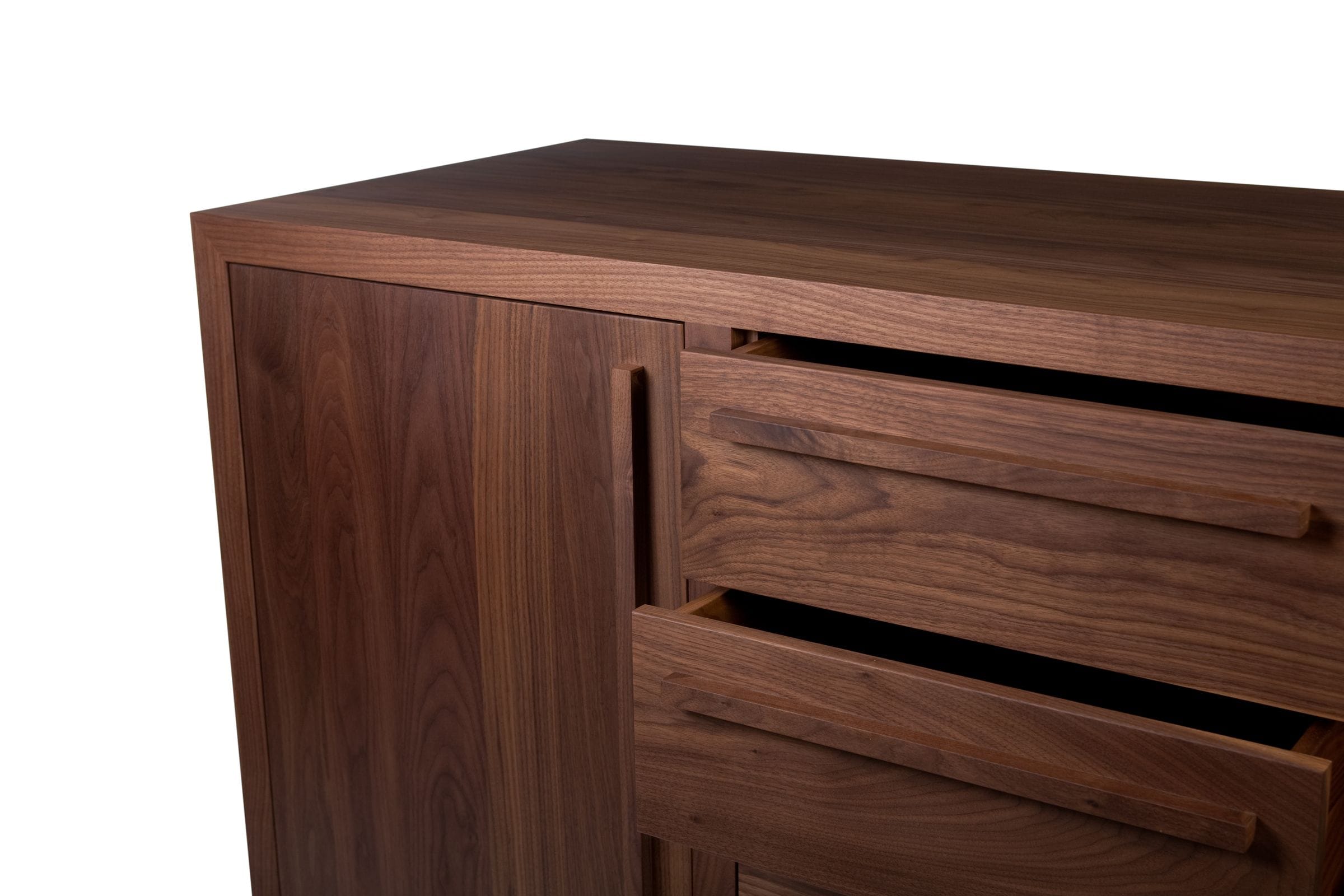 Close-up of open walnut sideboard drawers showing grain and slim wooden handles