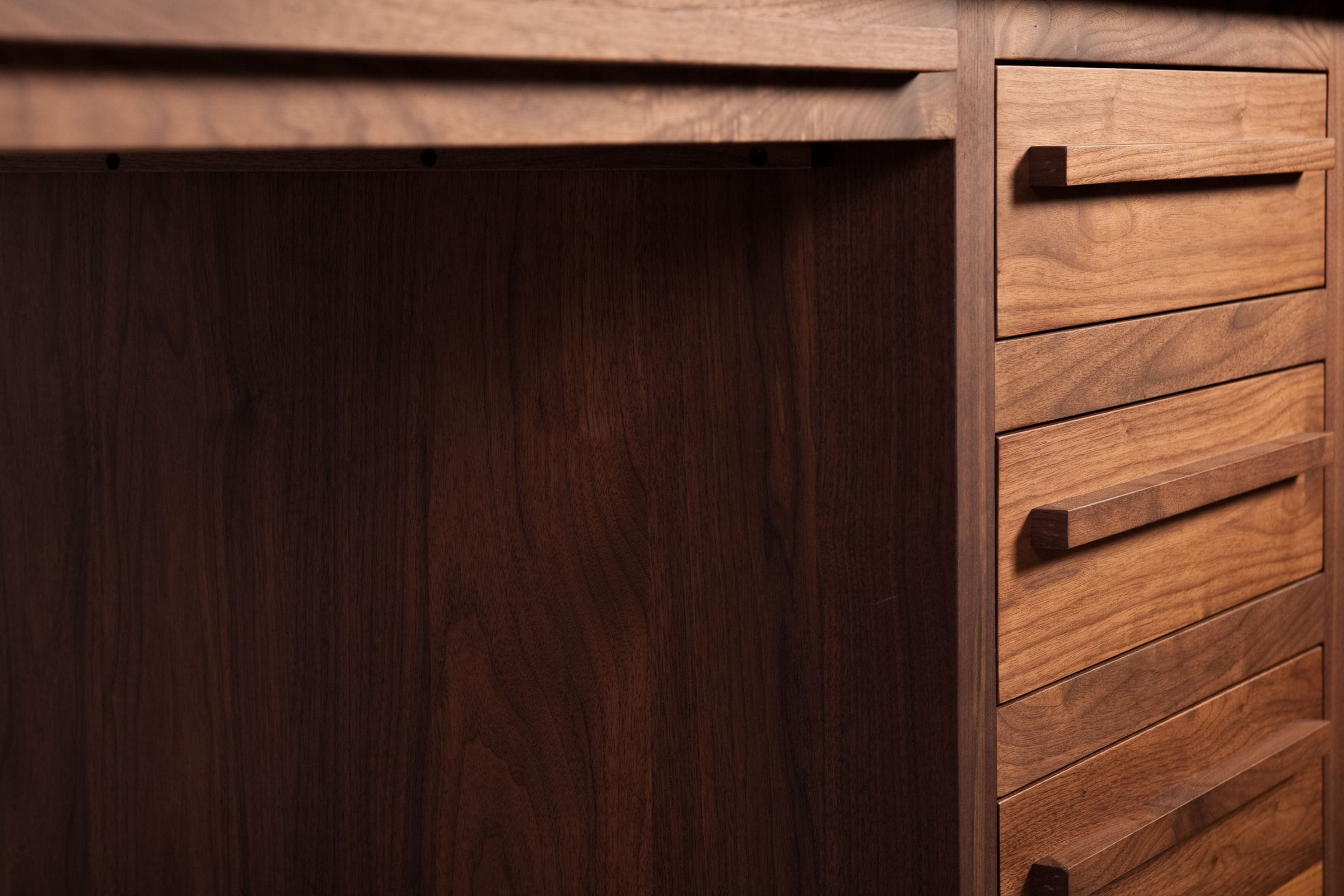 Kneehole and drawer bank detail of a solid walnut desk