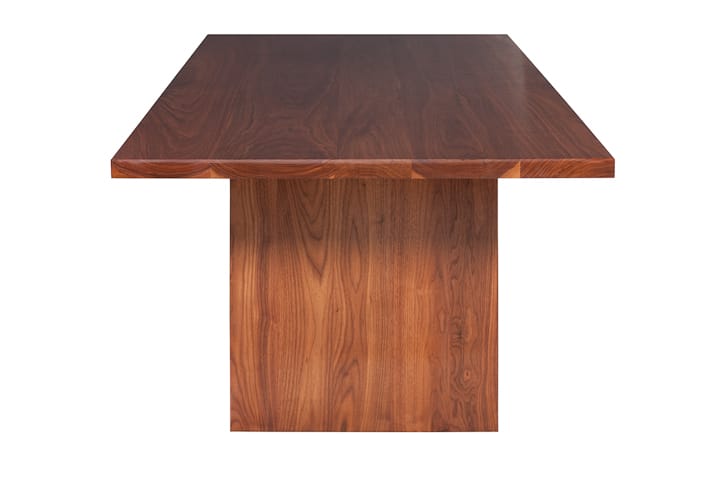 End view of a solid walnut dining table showing grain on the slab leg