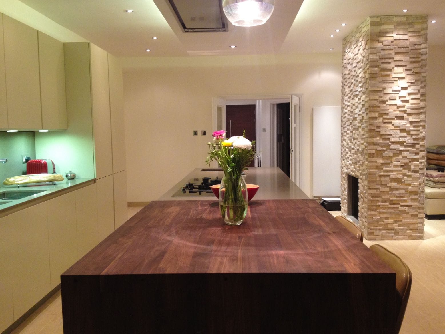 Chunky walnut wide block island top with vase of flowers in a cream modern kitchen