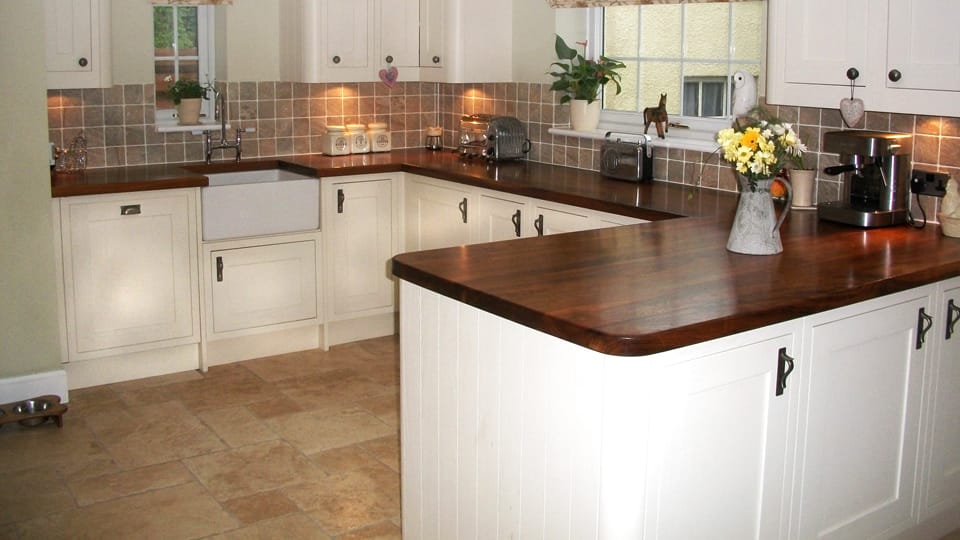 Dark walnut super stave worktops in a cream cottage kitchen with Belfast sink
