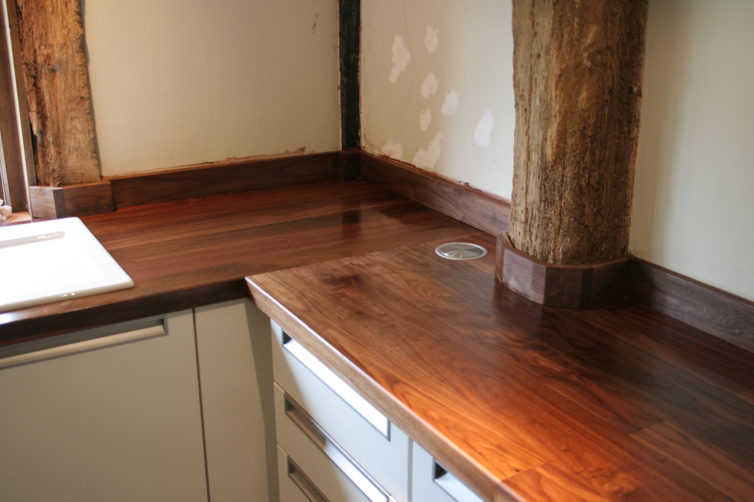 Walnut worktop scribed around an exposed timber post in a barn conversion kitchen