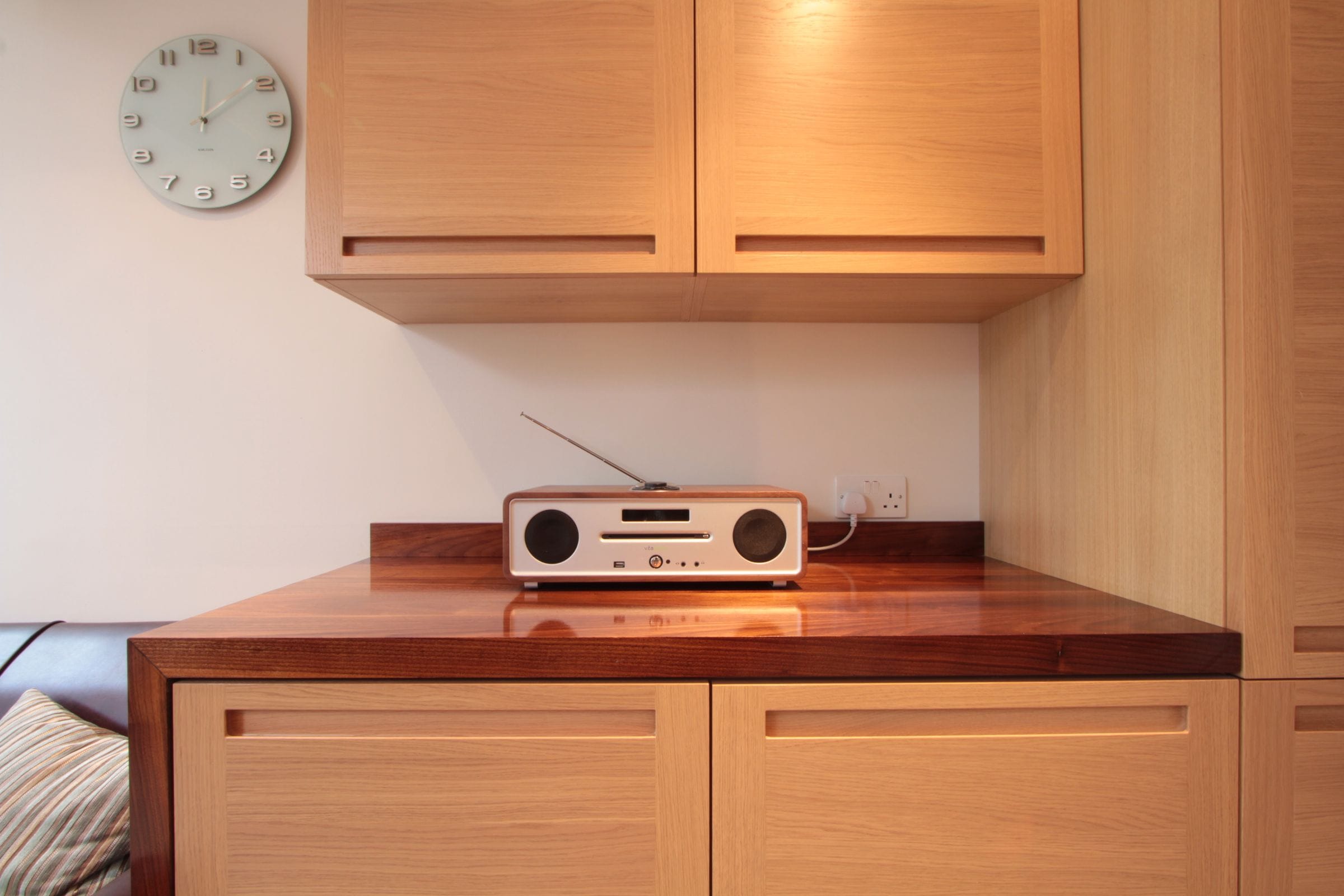 Walnut top on oak cabinets with a radio and wall clock in a living room alcove