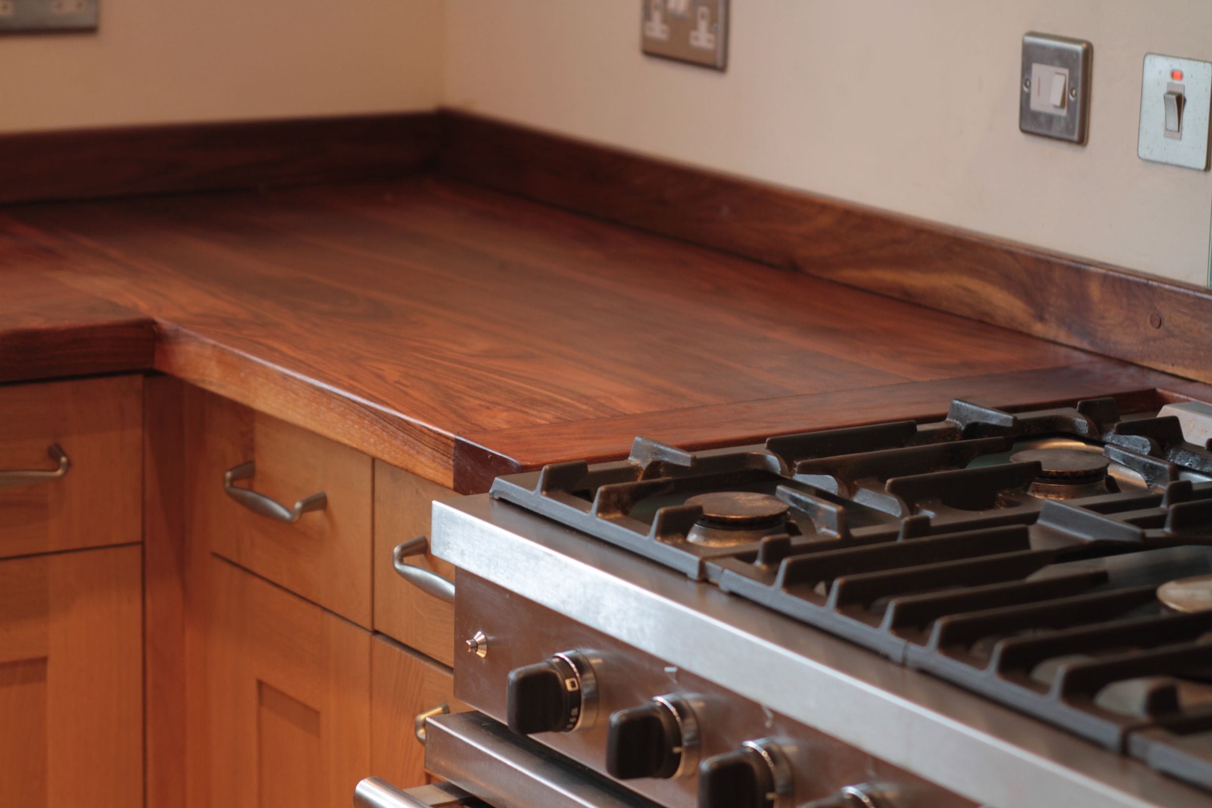 Walnut worktop with framed end detail beside a stainless range cooker