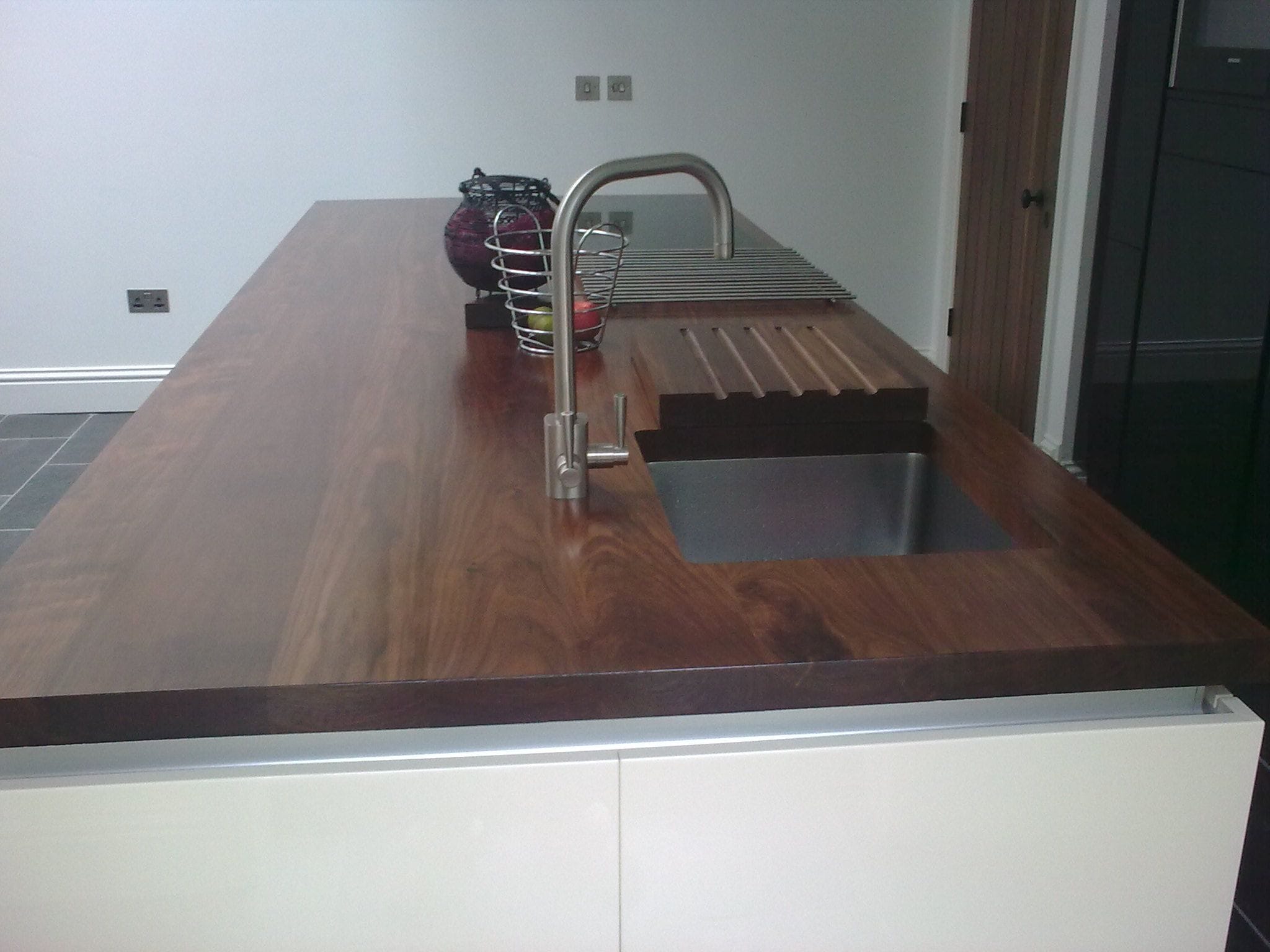 Thick walnut worktop with undermount sink, drainer grooves and stainless mixer tap