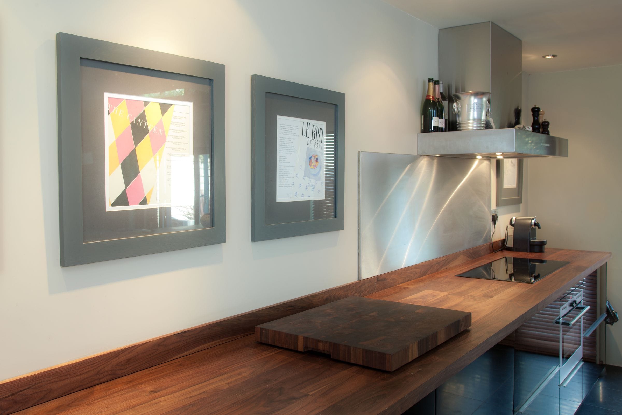 Walnut worktop run with end-grain chopping board beneath a stainless splashback