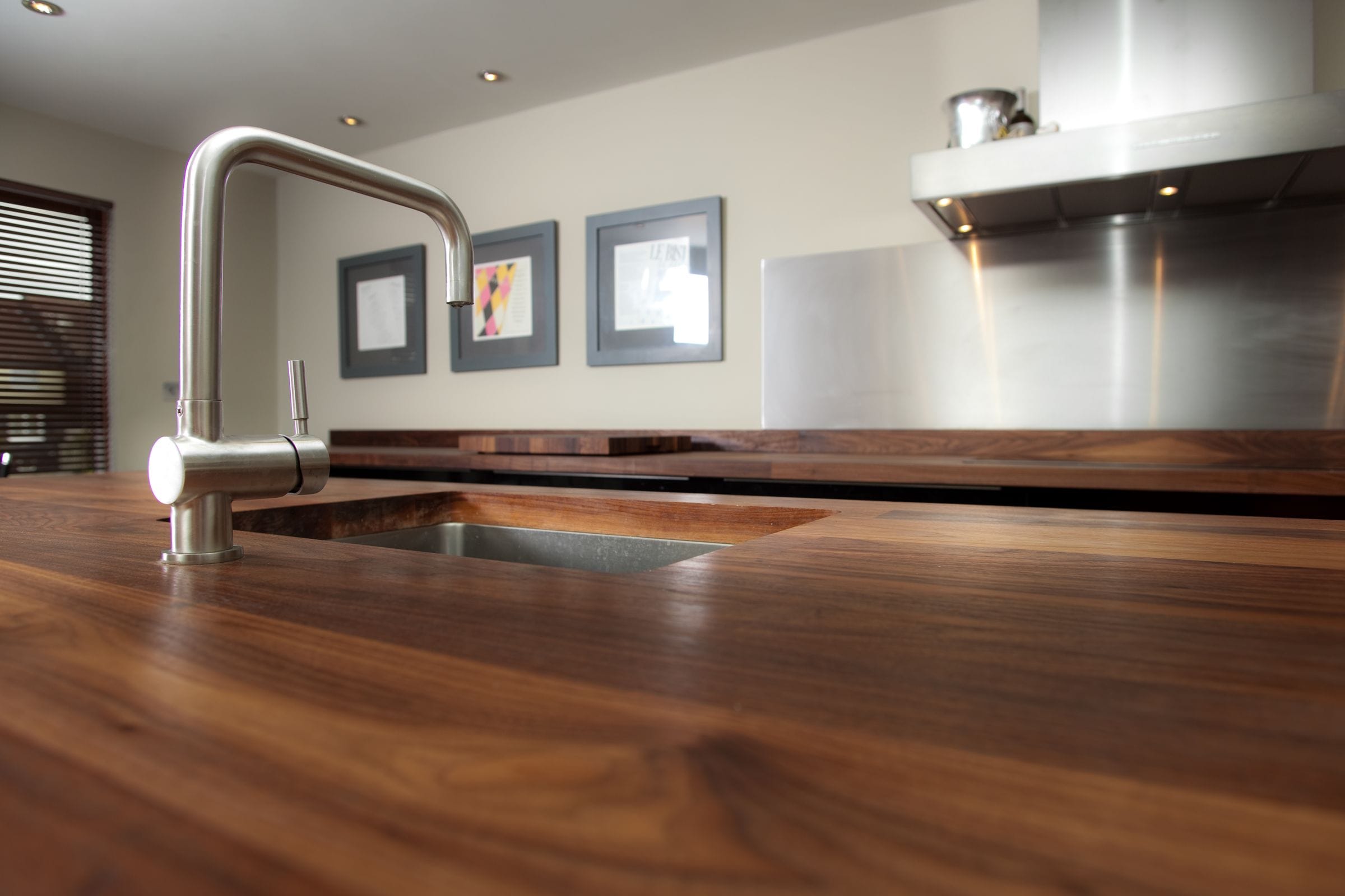 Close-up of walnut worktop grain with stainless tap over an undermount sink