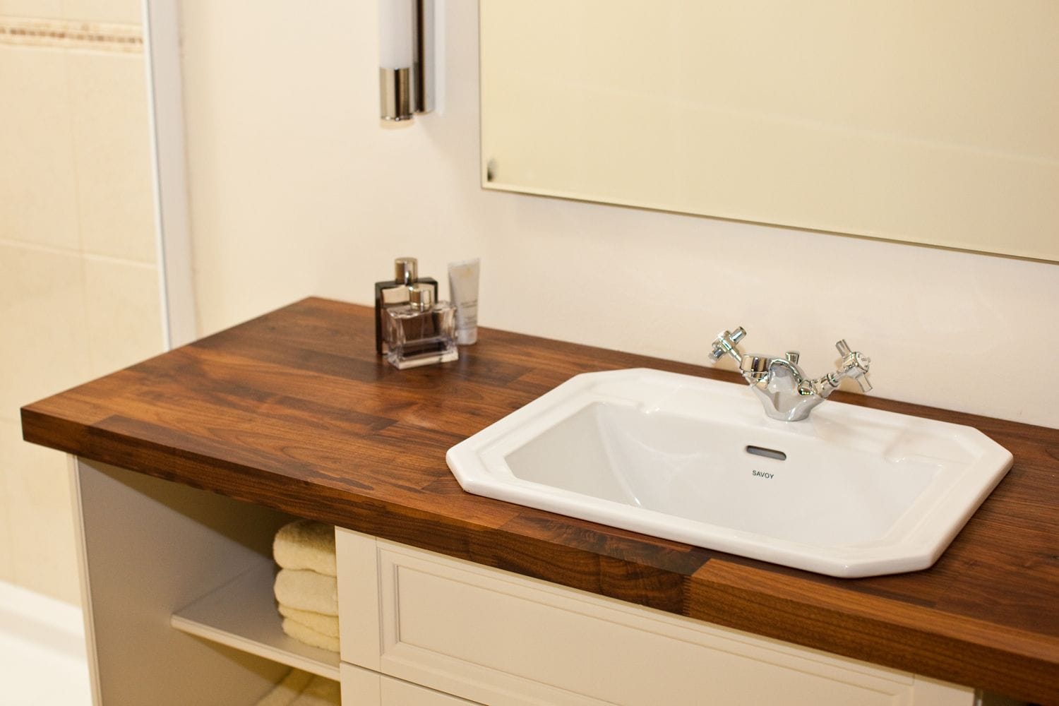 Walnut vanity top with inset white basin and chrome crosshead taps