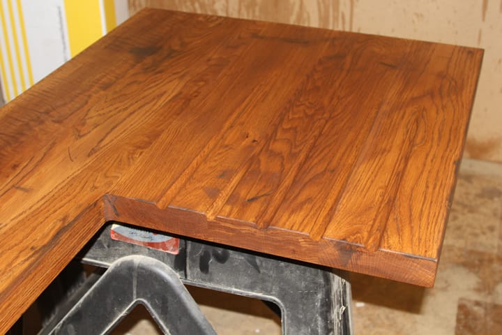 Oiled oak worktop with drainer grooves and cut-out resting on workshop trestles