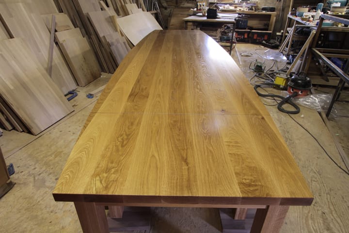 Boat-shaped full-stave oak boardroom table top under construction in the workshop