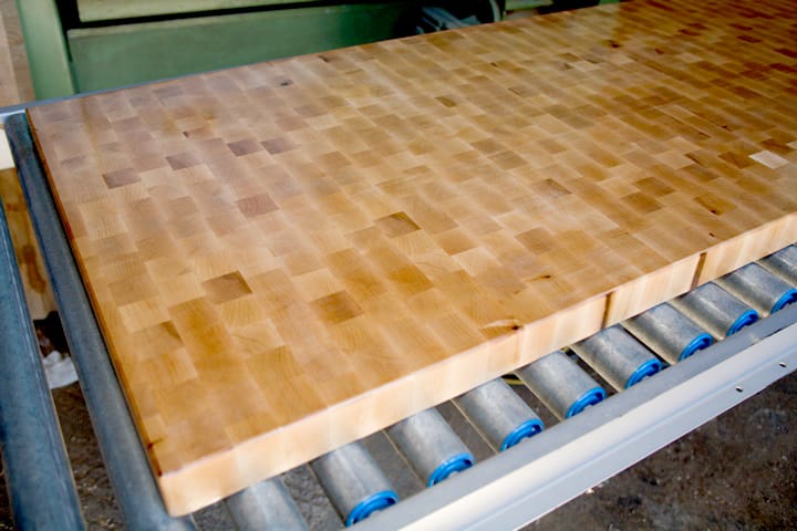 End-grain butcher's block worktop on workshop rollers showing chequerboard pattern