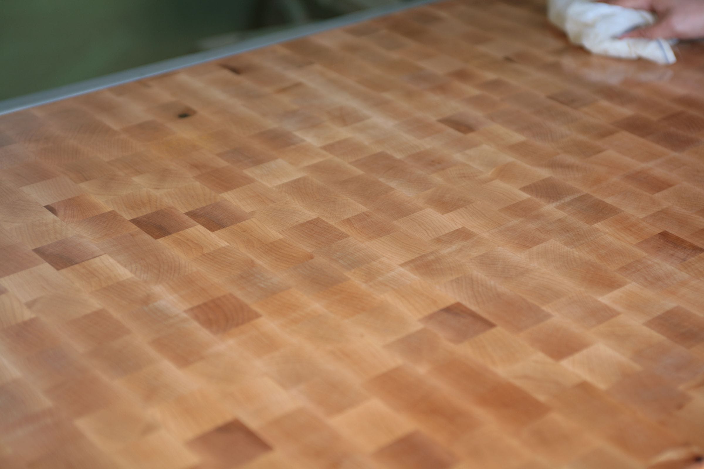 Hand-finishing an end-grain butcher's block surface with an oiling cloth
