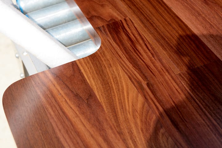 Rounded corner of a polished walnut worktop on workshop rollers