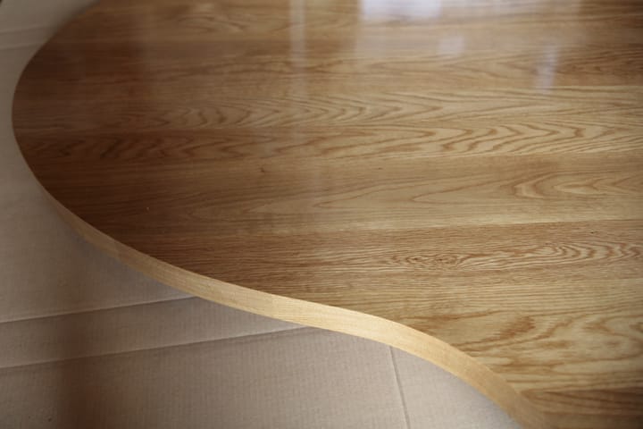 Sweeping curved edge of a lacquered oak worktop showing attractive grain