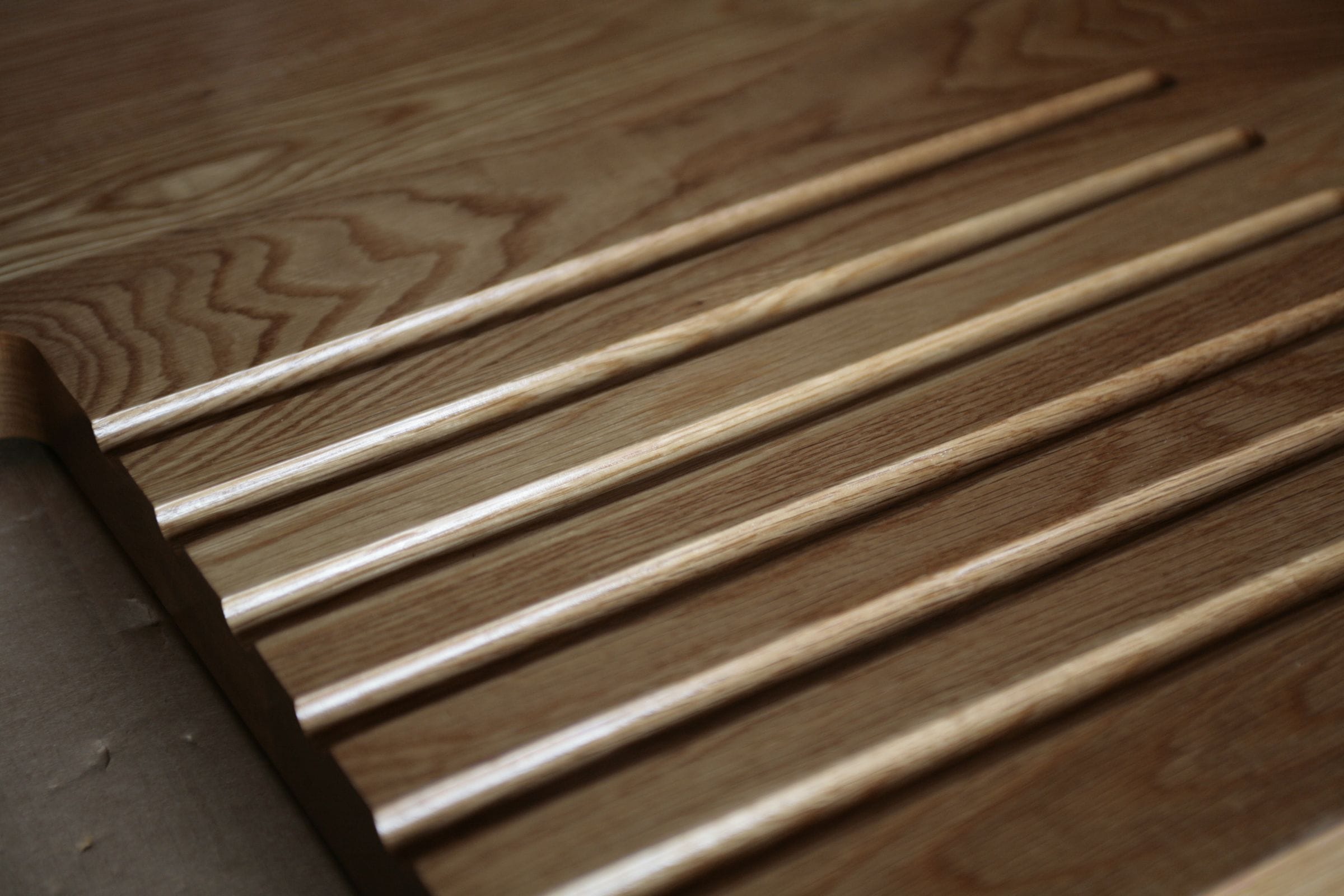 Close-up of routed drainage grooves cut into an oak draining board