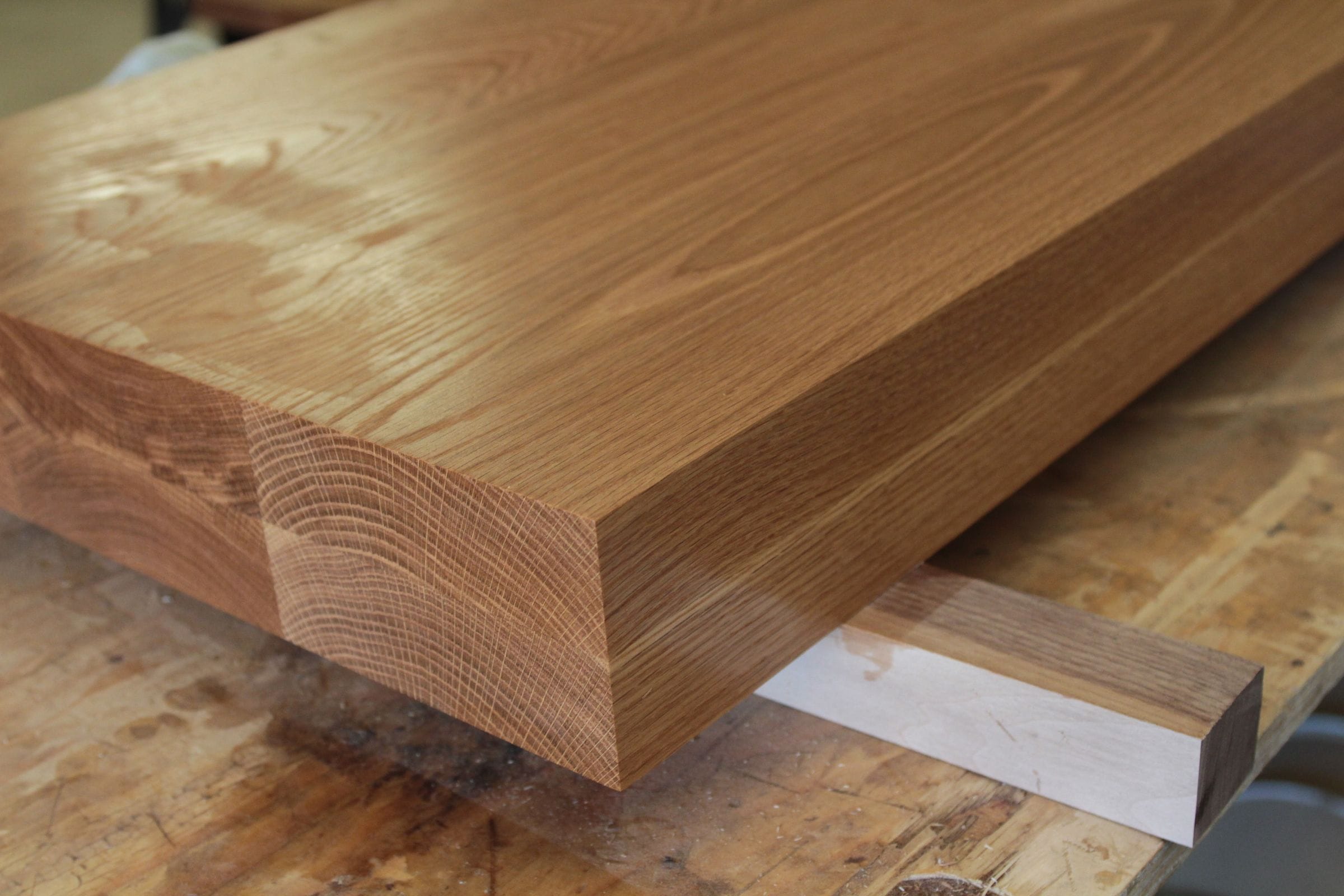 Thick full-stave oak worktop section on the workshop bench showing end grain