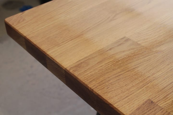 Corner detail of an oiled oak worktop with staggered stave joints