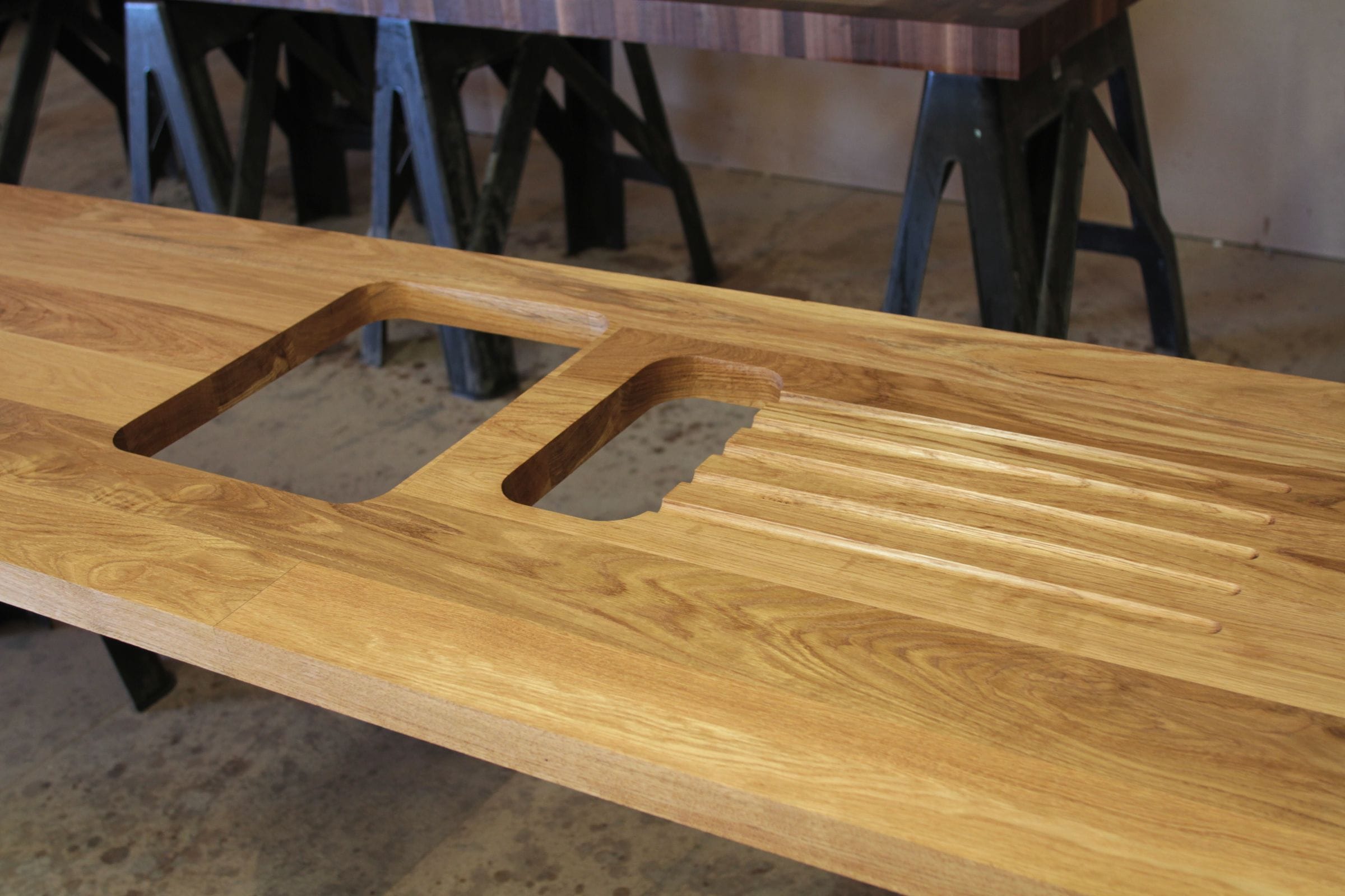 Oak worktop with sink cut-outs and grooved draining board on workshop trestles